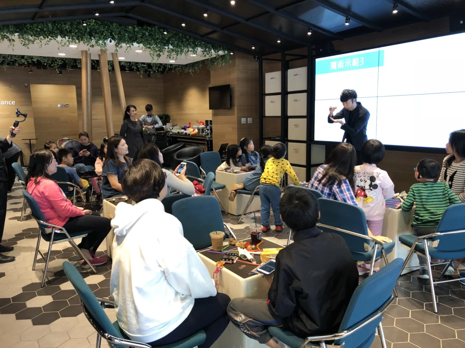 講師在前方示範魔術，學員坐在座位上觀看