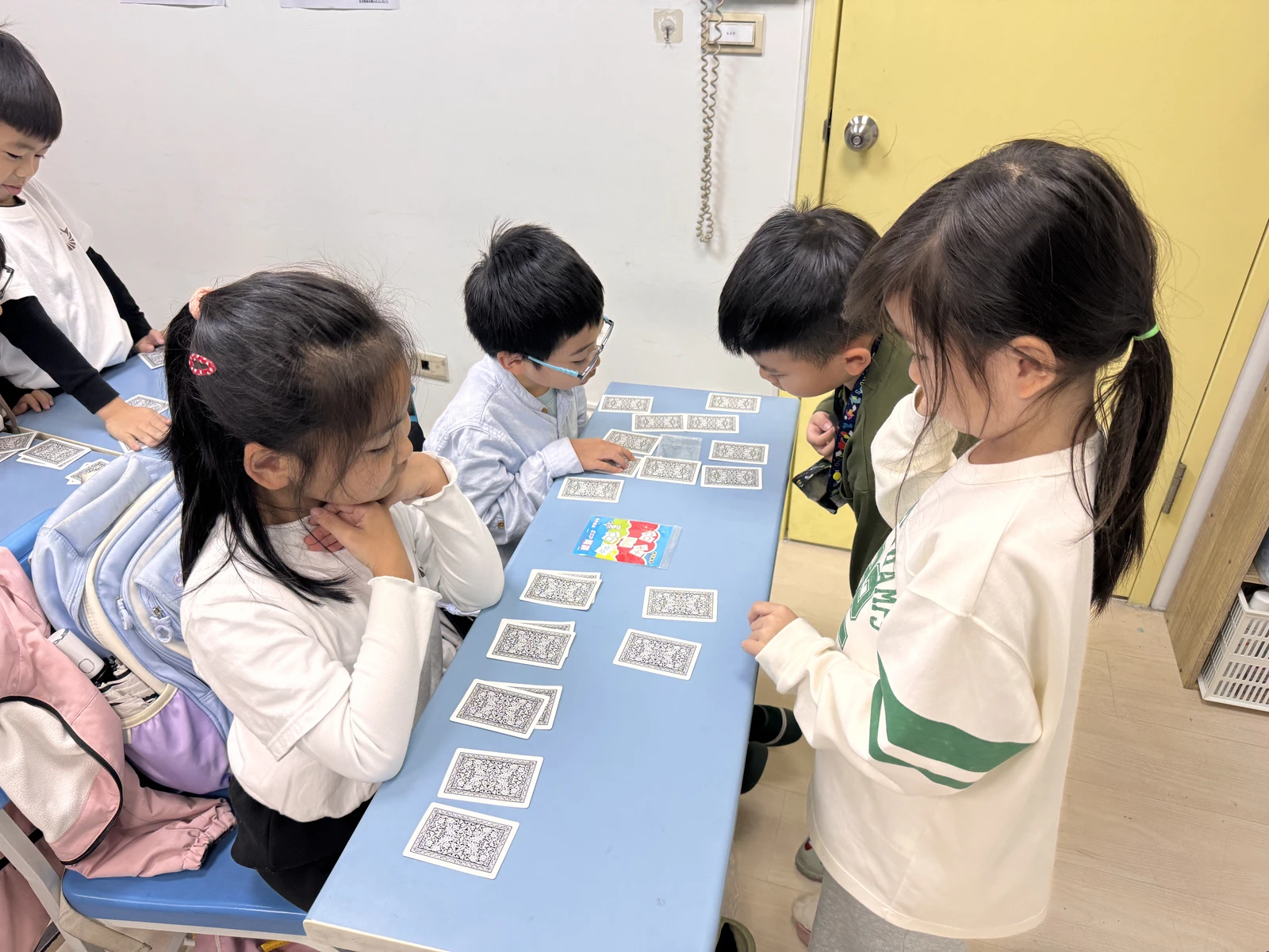 學員圍桌互相練習撲克牌魔術