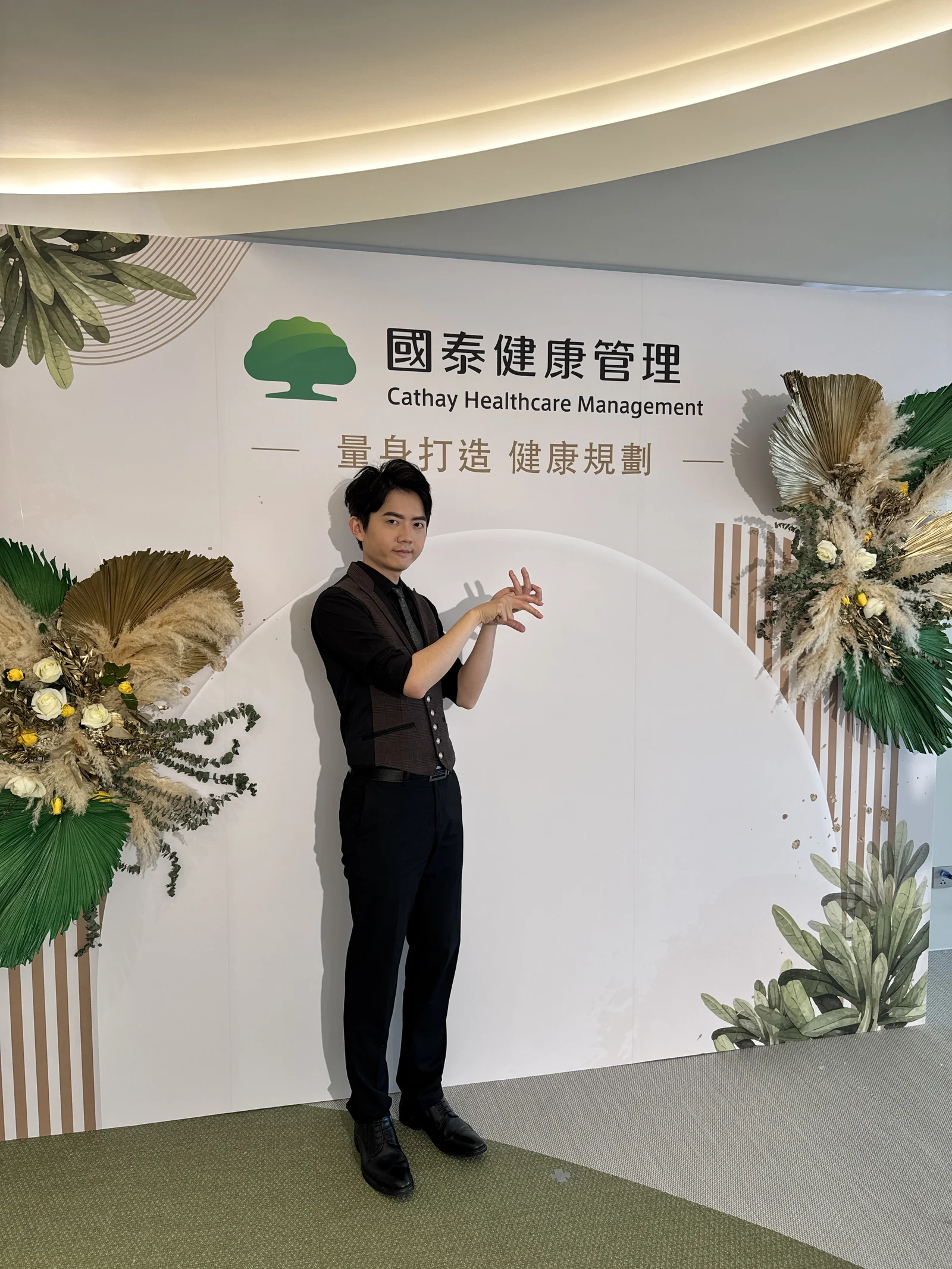 企業活動現場中，表演者於品牌背板前呈現手影姿態