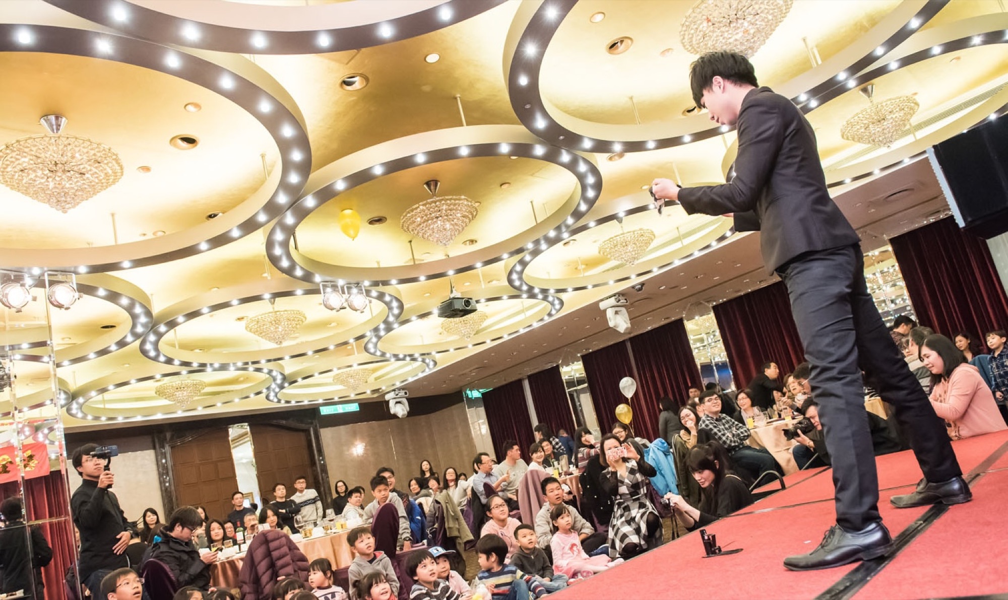 魔術師於舞台演出，來賓在座席欣賞